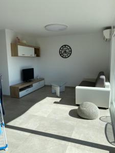 a white living room with a couch and a tv at Modern Living in Riazzino