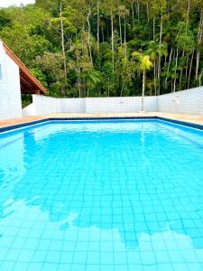 ein großer Pool mit blauem Wasser in der Unterkunft Apartamento Praia Grande Ubatuba in Ubatuba