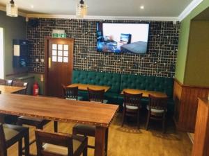 a restaurant with tables and chairs and a television on a wall at Queens Hotel in Stonehaven