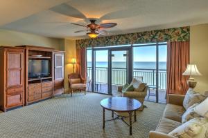 a living room with a couch and a television at Custom decor,oceanfront and spacious onsite restaurant pools pool bar Sleeps 10 in Myrtle Beach