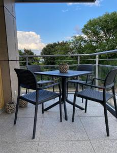 a table and chairs on a balcony with a view at Apartament Szot in Wilkasy