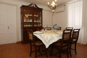 een eetkamer met een tafel met stoelen en een kroonluchter bij Casa da Catraia by Lisbon Village Apartments in Torrozelo