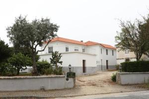 een groot wit huis met bomen ervoor bij Casa da Catraia by Lisbon Village Apartments in Torrozelo