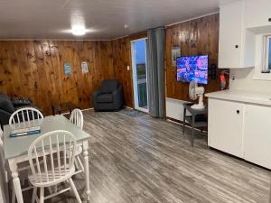 a kitchen and living room with a table and chairs at Cottages On PEI-Oceanfront in Bedeque