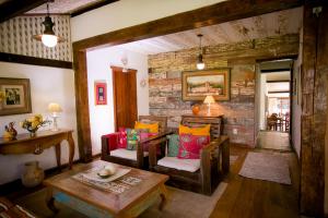 a living room with chairs and a table at Pouso do Bichinho 2 in Bichinho
