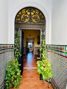 un pasillo con un arco con plantas. en Convento Hermana Esther, en Alosno