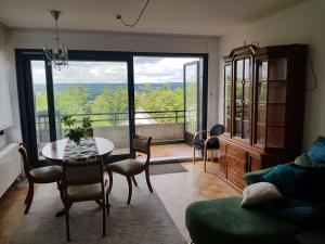 sala de estar con mesa y sillas y balcón en Ferienhaus mit phantastischer Aussicht auf Koblenz en Coblenza