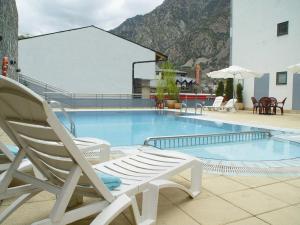 einen Pool mit einem weißen Sessel in der Unterkunft Zenit Diplomatic in Andorra la Vella