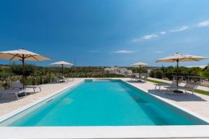 une piscine avec chaises et parasols dans l'établissement Country House il Gelso e l’Ulivo, à Noto