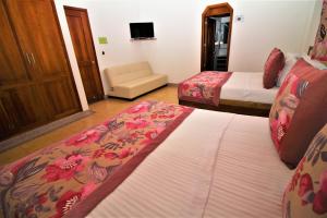 une chambre d'hôtel avec deux lits et un canapé dans l'établissement Amazilia Hotel, à Pereira