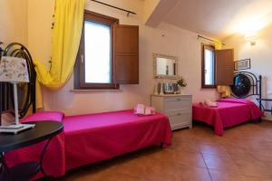 deux lits dans une chambre avec des draps roses dans l'établissement Country House il Gelso e l’Ulivo, à Noto 37 autres photos