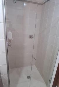 a shower with a glass door in a bathroom at Lindo Flat Aconchegante no Centro de Taguatinga in Taguatinga