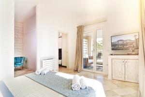 una camera bianca con un letto e un grande specchio di Villa Turquoise a Magomadas