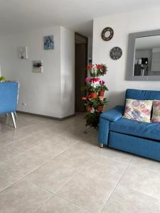 ein Wohnzimmer mit einem blauen Sofa und Fliesenboden in der Unterkunft Apartamento Medellín - Envigado in Envigado