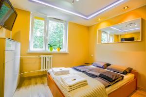 um quarto amarelo com uma cama e um espelho em W CENTRUM em Suwałki