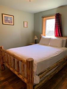 a bedroom with a wooden bed with a window at Methow River Lodge Cabins in Winthrop