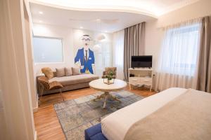 a room with a bed and a couch and a tv at Meri Boutique Hotel in Korçë