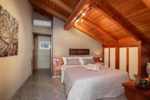 sypialnia z dużym białym łóżkiem i drewnianym sufitem w obiekcie b&b Al Castel w mieście Pont-Saint-Martin