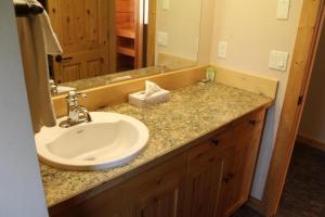 a bathroom counter with a sink and a mirror at Methow River Lodge Cabins in Winthrop