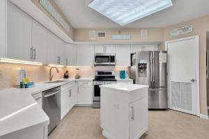 a kitchen with white cabinets and stainless steel appliances at Windward Pointe Unit 901 in Orange Beach