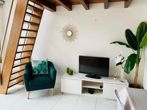uma sala de estar com uma televisão e uma cadeira em Pérola de Viana - Cabedelo em Viana do Castelo