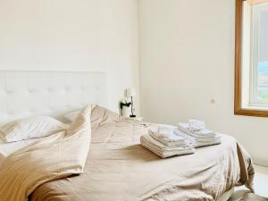 um quarto branco com uma cama com toalhas em Pérola de Viana - Cabedelo em Viana do Castelo