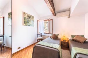 two beds in a room with white walls at Colombina Like at home 3 bedrooms fully equipped air conditioned in Venice
