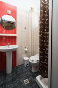 La salle de bains est pourvue de toilettes blanches et d'un lavabo. dans l'établissement Villa Irida Sun, à Olympiakí Aktí