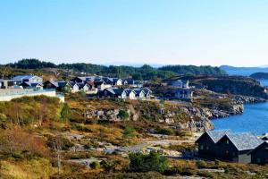 un grupo de casas en una colina junto al agua en Austefjordtunet 15 en Forland