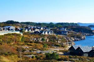 un grupo de casas en una colina junto al agua en Austefjordtunet 15, en Forland