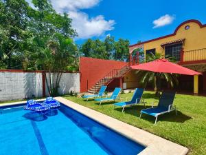 a swimming pool with chairs and a red umbrella at Not for rent in Cancún