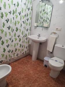 a bathroom with a sink and a toilet and a mirror at Los Príncipes in Palos de la Frontera