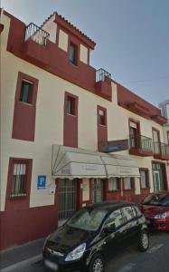 a black car parked in front of a building at Los Príncipes in Palos de la Frontera