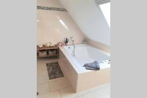a white bathroom with a tub in a room at Ferienwohnung Landhaus Auf dem Hollo in Petershagen +21 photos
