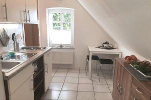 eine Küche mit einem Waschbecken und einem Tisch in der Unterkunft Ferienwohnung Landhaus Auf dem Hollo in Petershagen