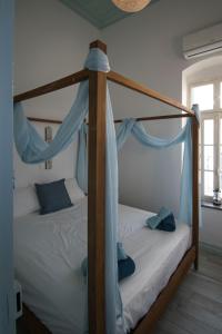 a bedroom with a four poster bed with blue drapes at Villa Sylvia in Symi