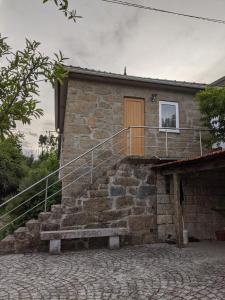 ein Steingebäude mit einer Treppe und einem Fenster in der Unterkunft Quinta da Tia in Baiões