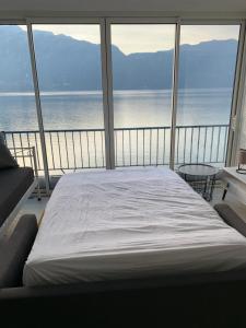 Bett in einem Zimmer mit Meerblick in der Unterkunft Le Lamartine, vue magnifique face au Lac du Bourget in Aix-les-Bains