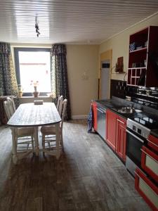 eine Küche mit einem Tisch und eine Küche mit roten Schränken in der Unterkunft Ferienwohnung Sunna in Lieser