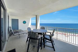 a balcony with a table and chairs and the ocean at Windward Point Unit 1004 in Orange Beach