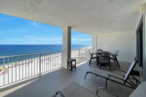 a balcony with a table and chairs and the ocean at Windward Point Unit 1004 in Orange Beach