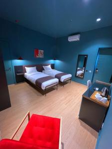 Habitación azul con cama y sofá rojo en Green Rooms en Kutaisi