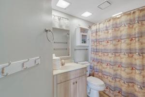a bathroom with a toilet sink and a shower curtain at Windward Point Unit 1004 in Orange Beach