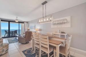 a dining room and living room with a table and chairs at Windward Point Unit 1004 in Orange Beach