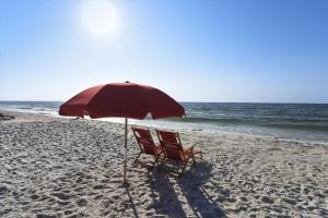 a chair sitting under an umbrella on the beach at Windward Point Unit 1004 in Orange Beach