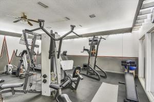 a gym with several tread machines and a ceiling fan at Windward Point Unit 1004 in Orange Beach