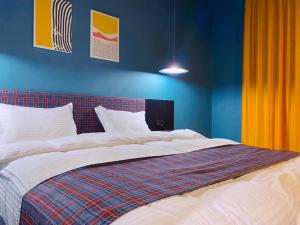 a bedroom with a large bed with blue walls at Green Rooms in Kutaisi