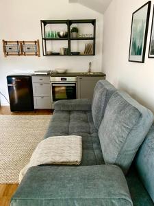ein Wohnzimmer mit einem Sofa und einer Küche in der Unterkunft Galerie Apartment Self-Check-In in Kolbermoor