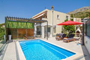 una villa con piscina y una casa en Arky, en Podstrana