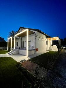 a white house with lights on the side of it at Agora LX Studios & Suites in Thessaloniki